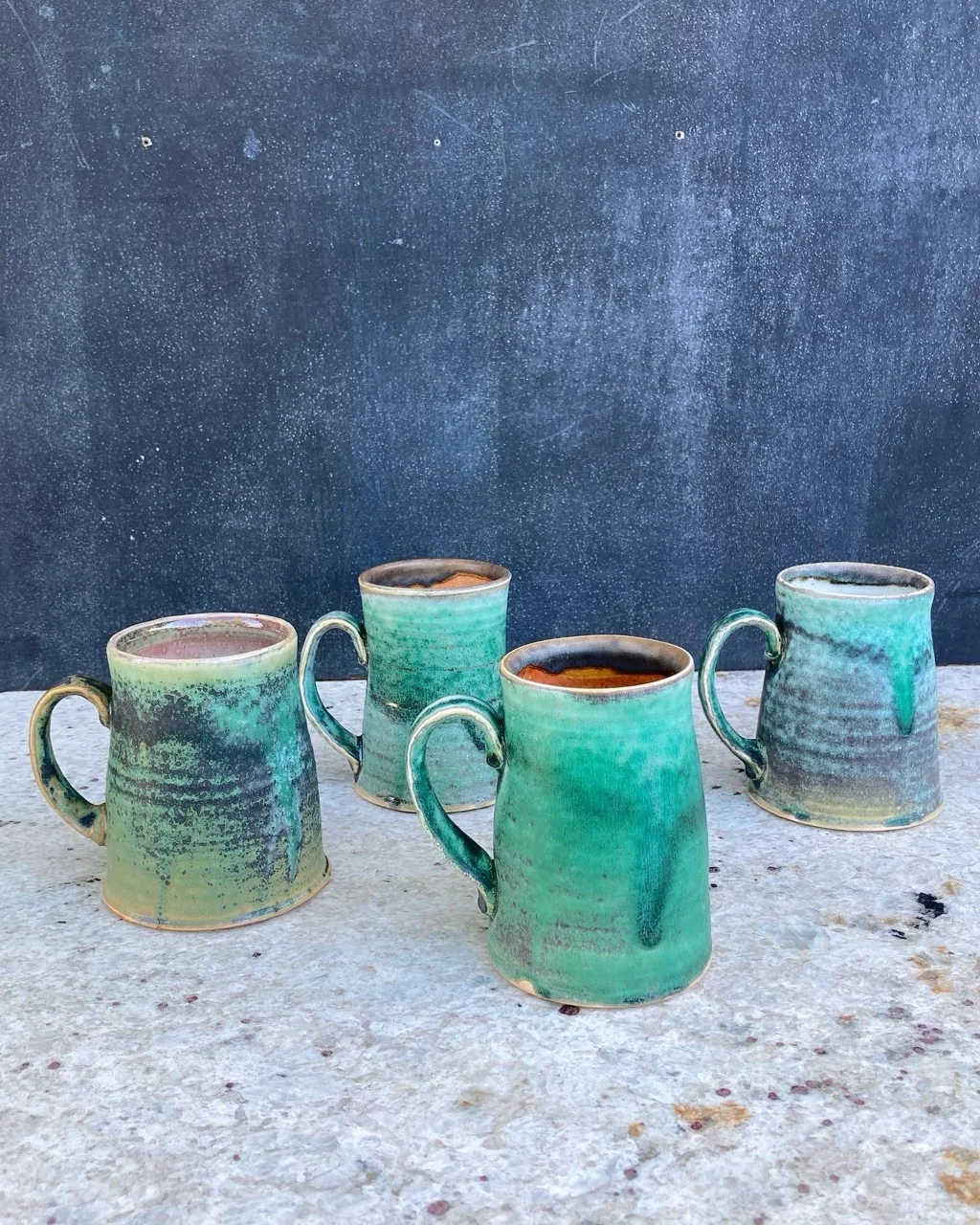 Four mugs with copper green soda glaze
