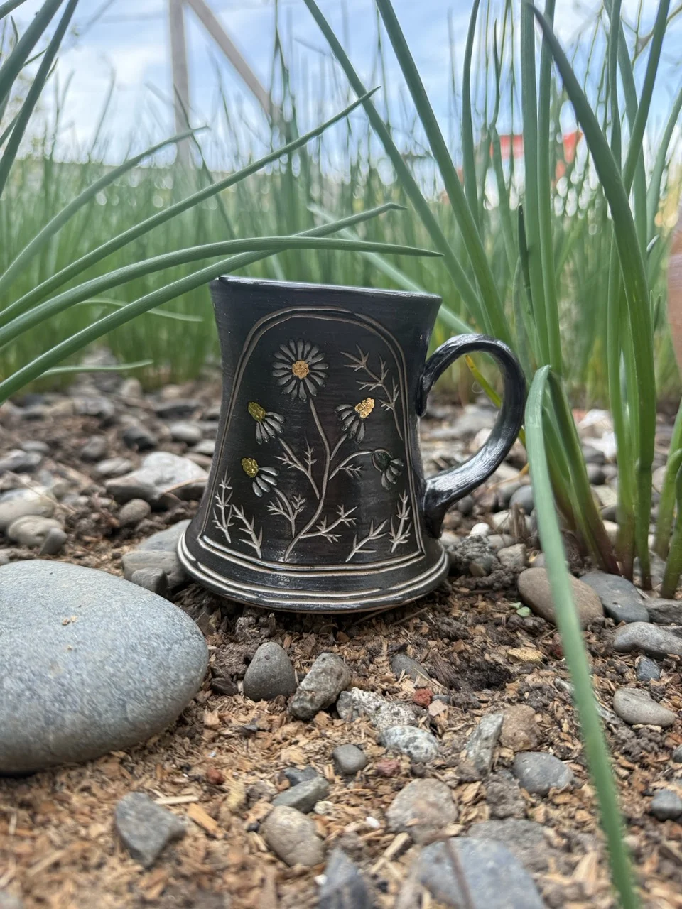 Black mug with carved and painted wildflowers