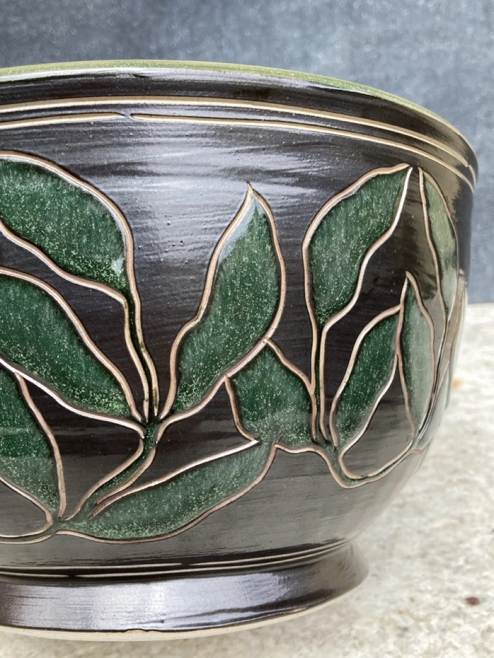 black bowl with dark green leaves