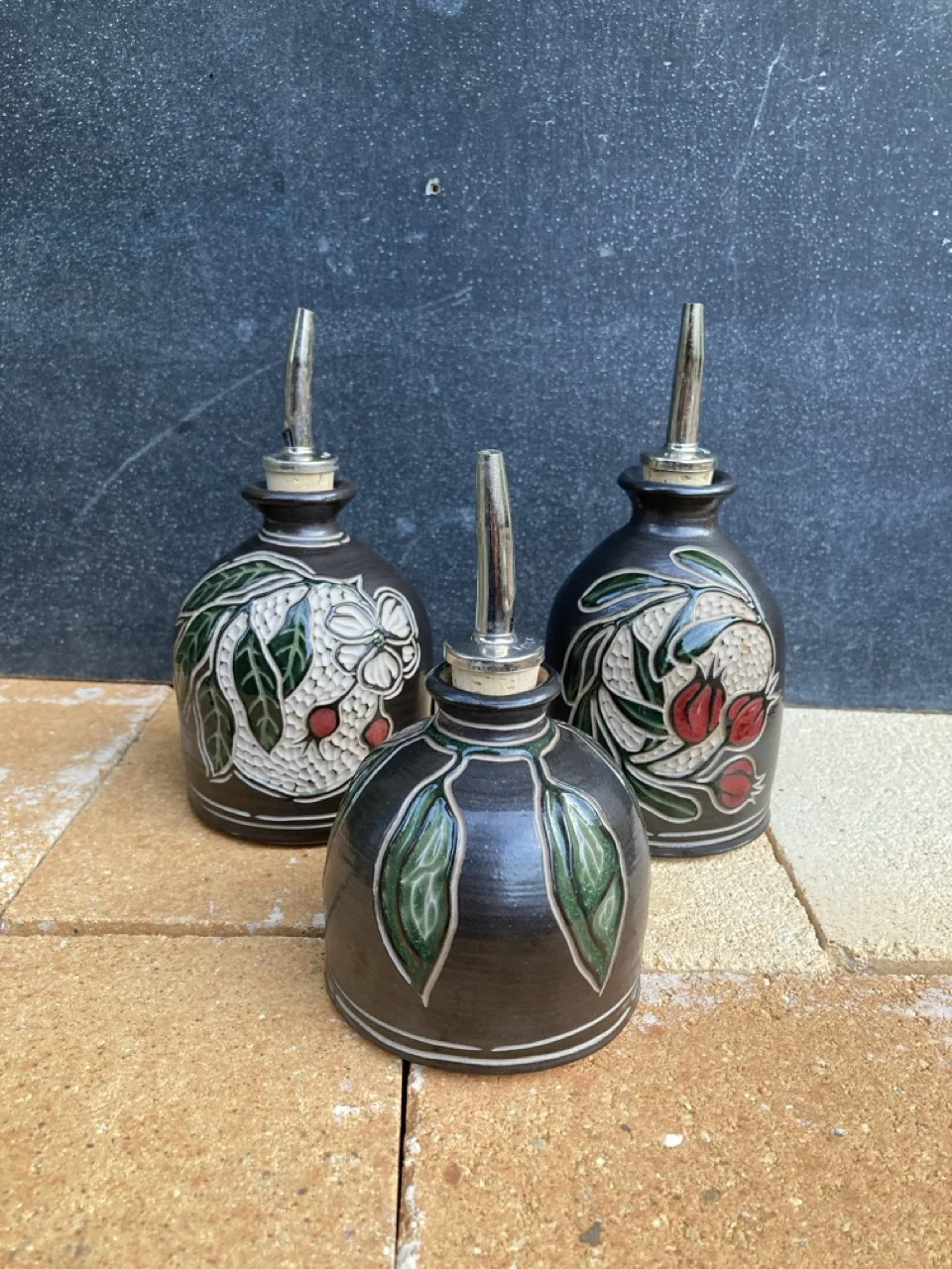 Three oil bottles with floral painted carvings