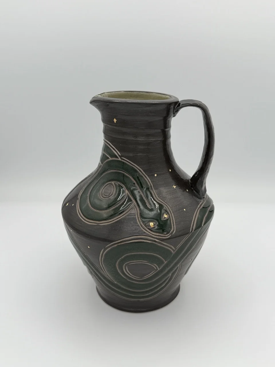 Pitcher with a dark green snake surrounded by gold stars
