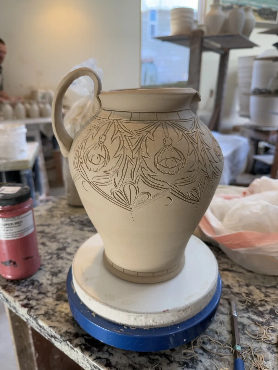 Pitcher with floral carvings, pre-firing
